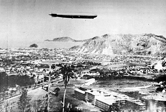O 'Graf Zeppelin' sobrevoando Santos, tendo em primeiro plano o hospital da Santa Casa (clique na imagem para obter detalhes e crditos)